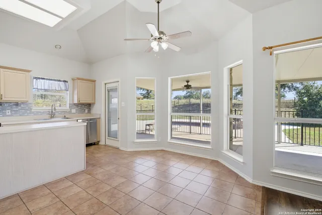 a open kitchen with white cabinets and white appliances