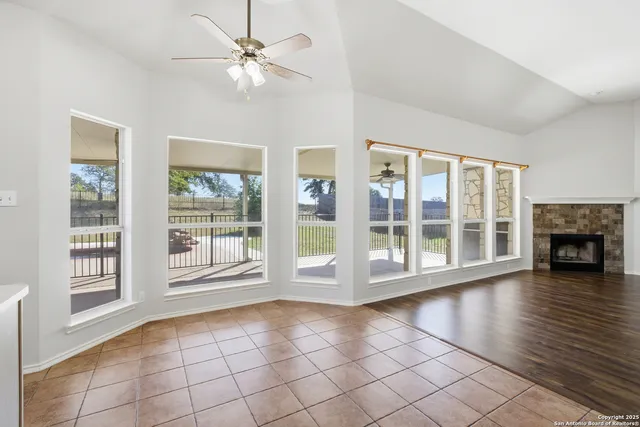 a view of an empty room with window wooden floor and a fire place