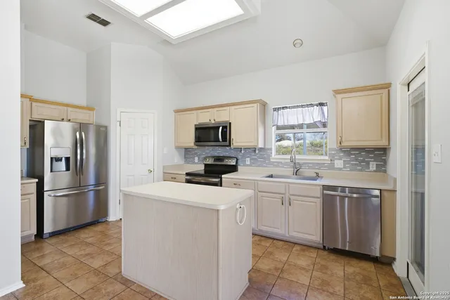 a kitchen with a sink appliances and cabinets