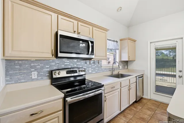 a kitchen with stainless steel appliances a stove a sink and a microwave