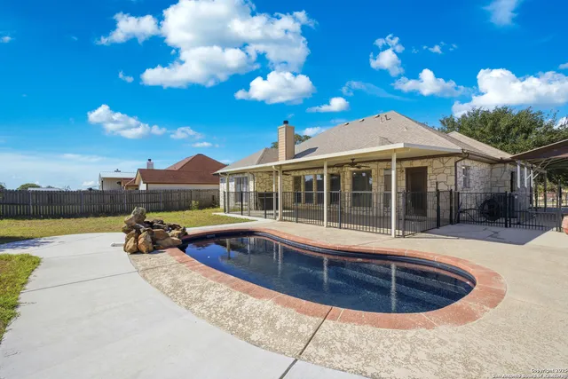 a view of a house with swimming pool and sitting area
