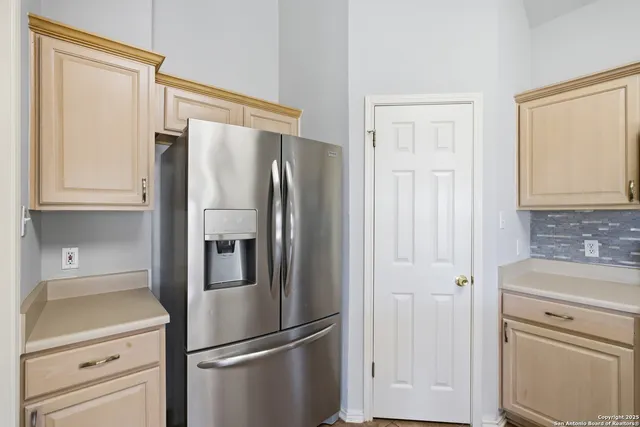 a metallic refrigerator freezer sitting in a kitchen