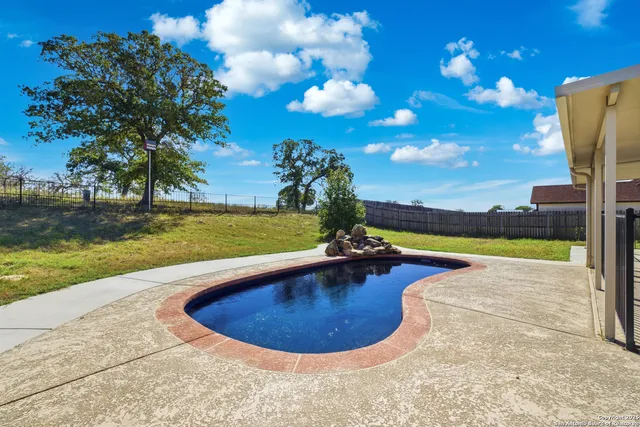 a view of a house with backyard and sitting area