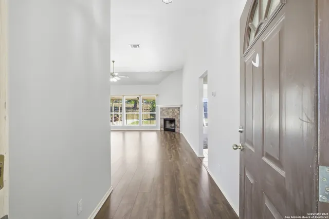 a view of a hallway with wooden floor and a window