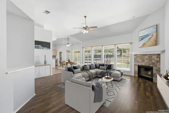 a living room with furniture fireplace and wooden floor
