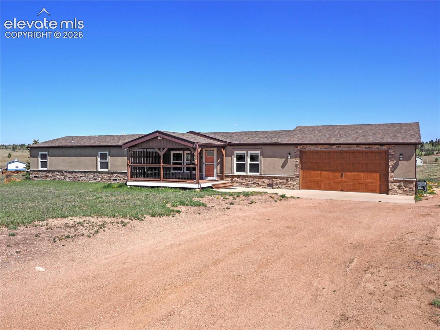 83 Ridge Point Circle Divide, CO 80814 - Photo 1 of 33 Single-story property with a composite shingle roof, stone and stucco exterior, an attached screened porch, a wood-finish garage door, and a concrete driveway apron
