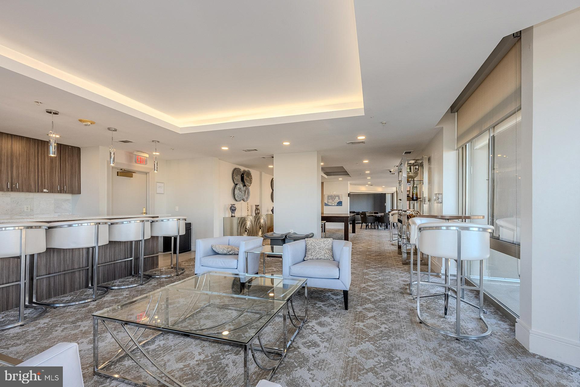 3650 South Glebe Road, Unit 460 Arlington, VA 22202 - Photo 29 of 38 a living room with couches chairs and kitchen view with wooden floor