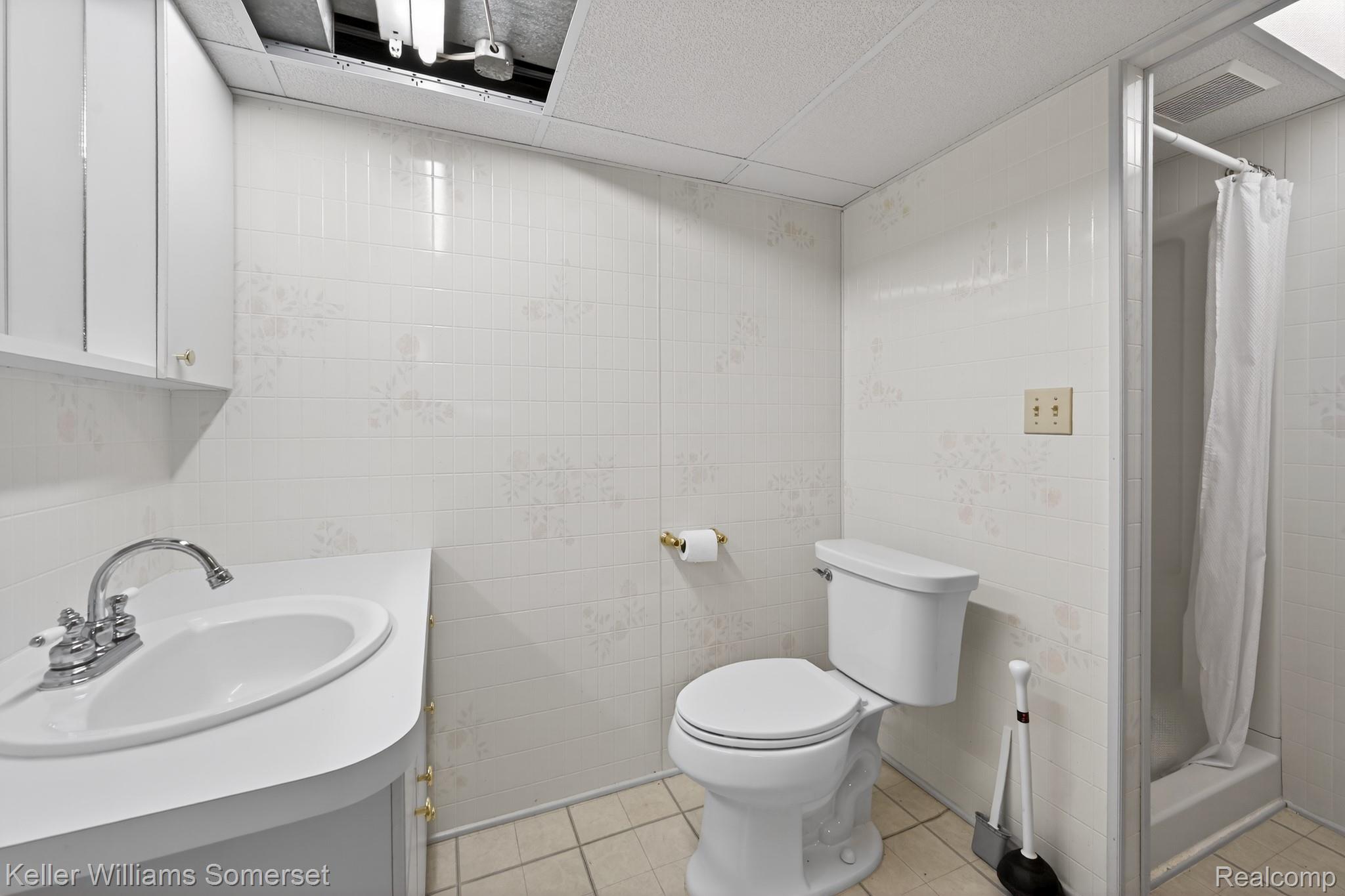 1681 Oxford Road Grosse Pointe, MI 48236 - Photo 22 of 25 Bathroom featuring a shower stall, vanity, a paneled ceiling, light tile patterned floors, and tile walls