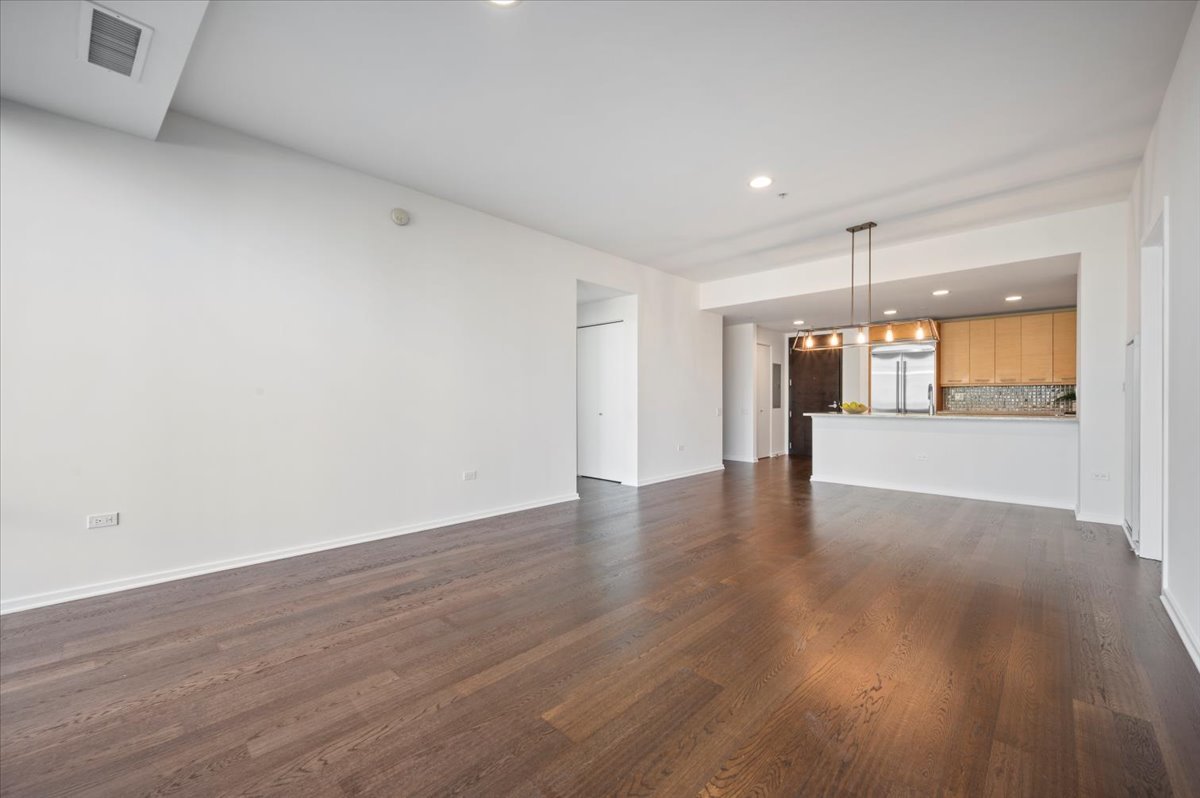 240 East Illinois Street, Unit 2204 Chicago, IL 60611 - Photo 16 of 50 a view of a big room with wooden floor and a kitchen