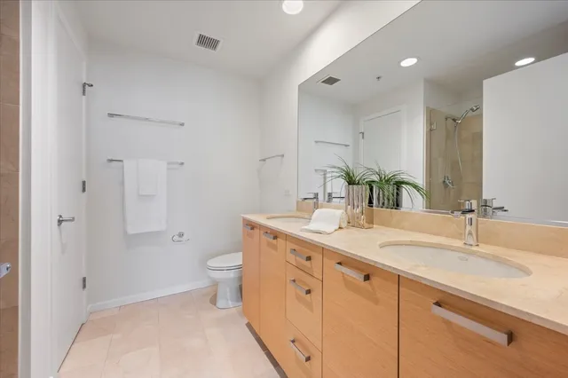 a spacious bathroom with a granite countertop sink a toilet and a shower