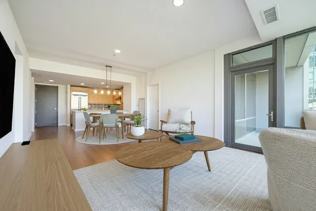 a living room with furniture a flat screen tv and a table