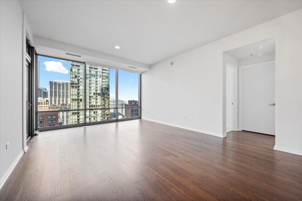 240 East Illinois Street, Unit 2204 Chicago, IL 60611 - Photo 7 of 50 a view of an empty room with wooden floor and a window