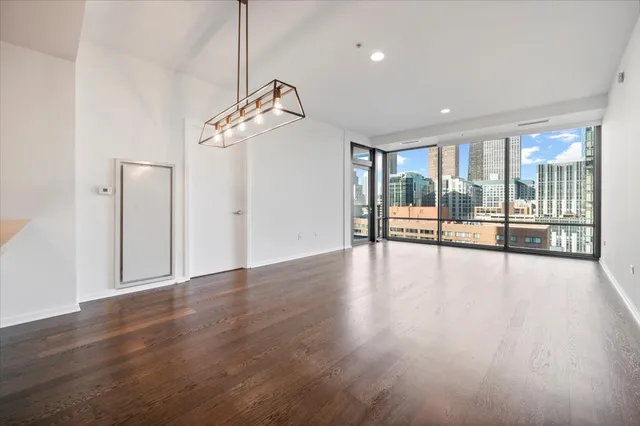 a view of a livingroom with wooden floor and a ceiling fan