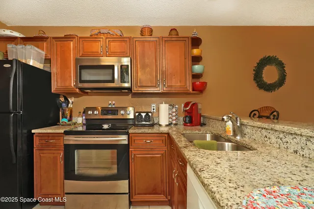 a kitchen with stainless steel appliances granite countertop a stove a sink and a microwave