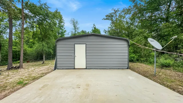 a backyard of a house with plants and large trees