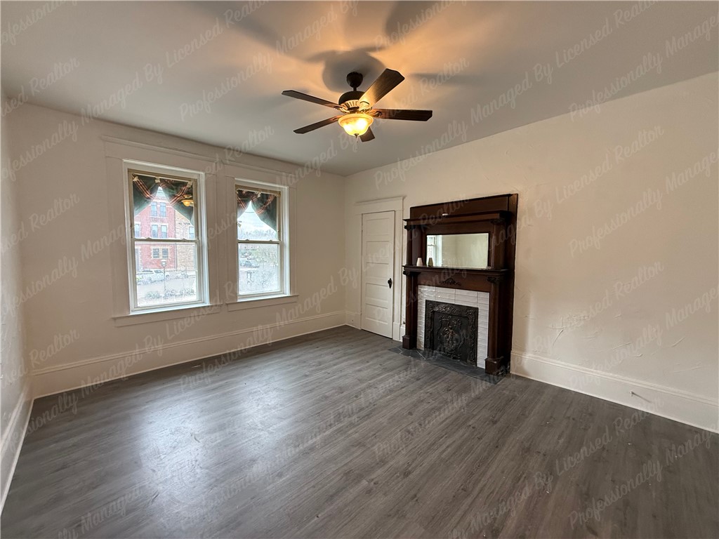 44 West High Street, Unit B Springfield, OH 45502 - Photo 9 of 31 This bright room features durable flooring and a decorative fireplace, creating a cozy and inviting atmosphere.