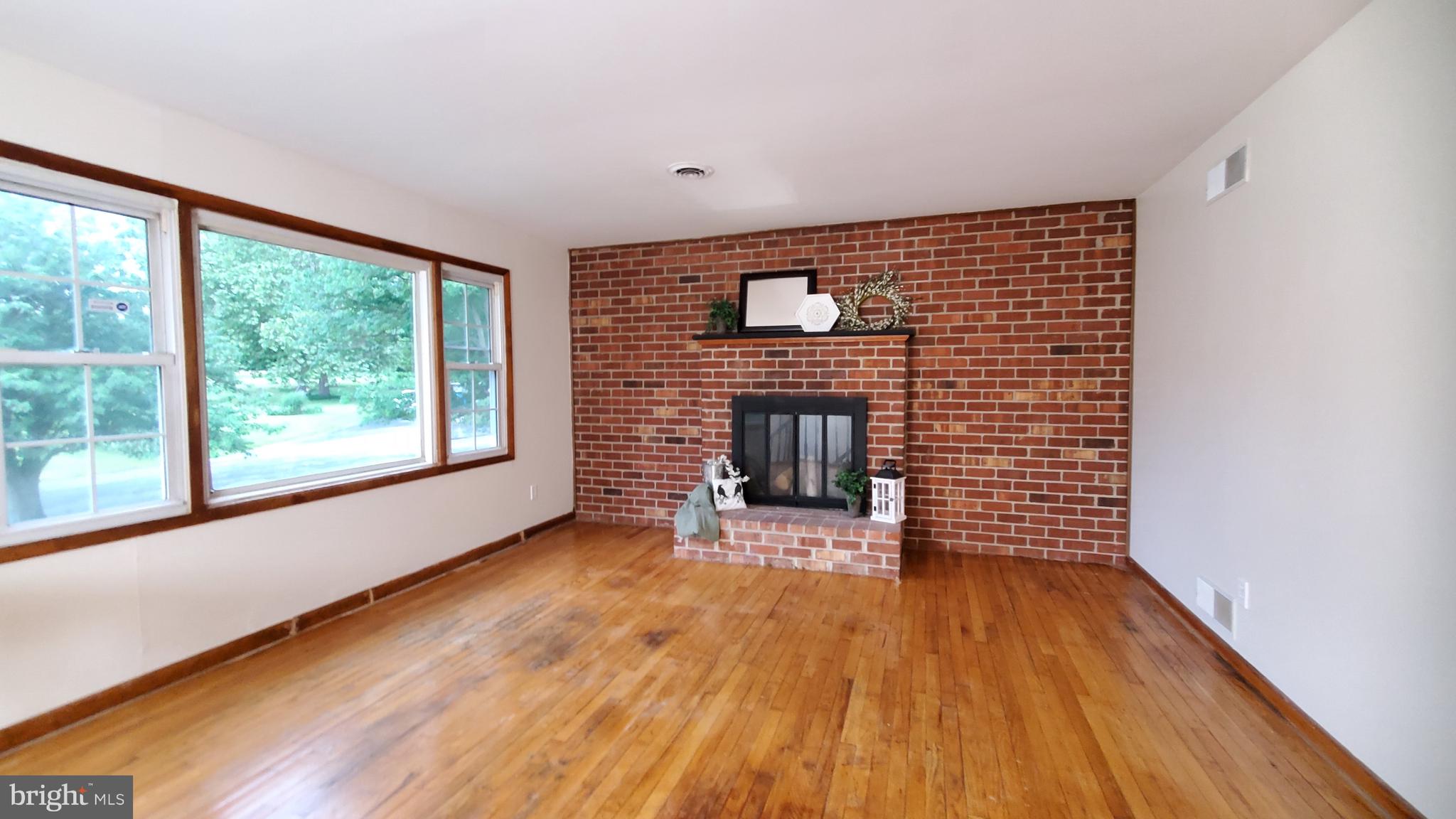 70 Zion Acres Road North East, MD 21901 - Photo 4 of 21 a view of empty room with wooden floor and fireplace