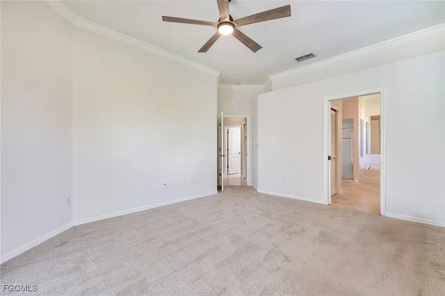 an empty room with closet and a ceiling fan