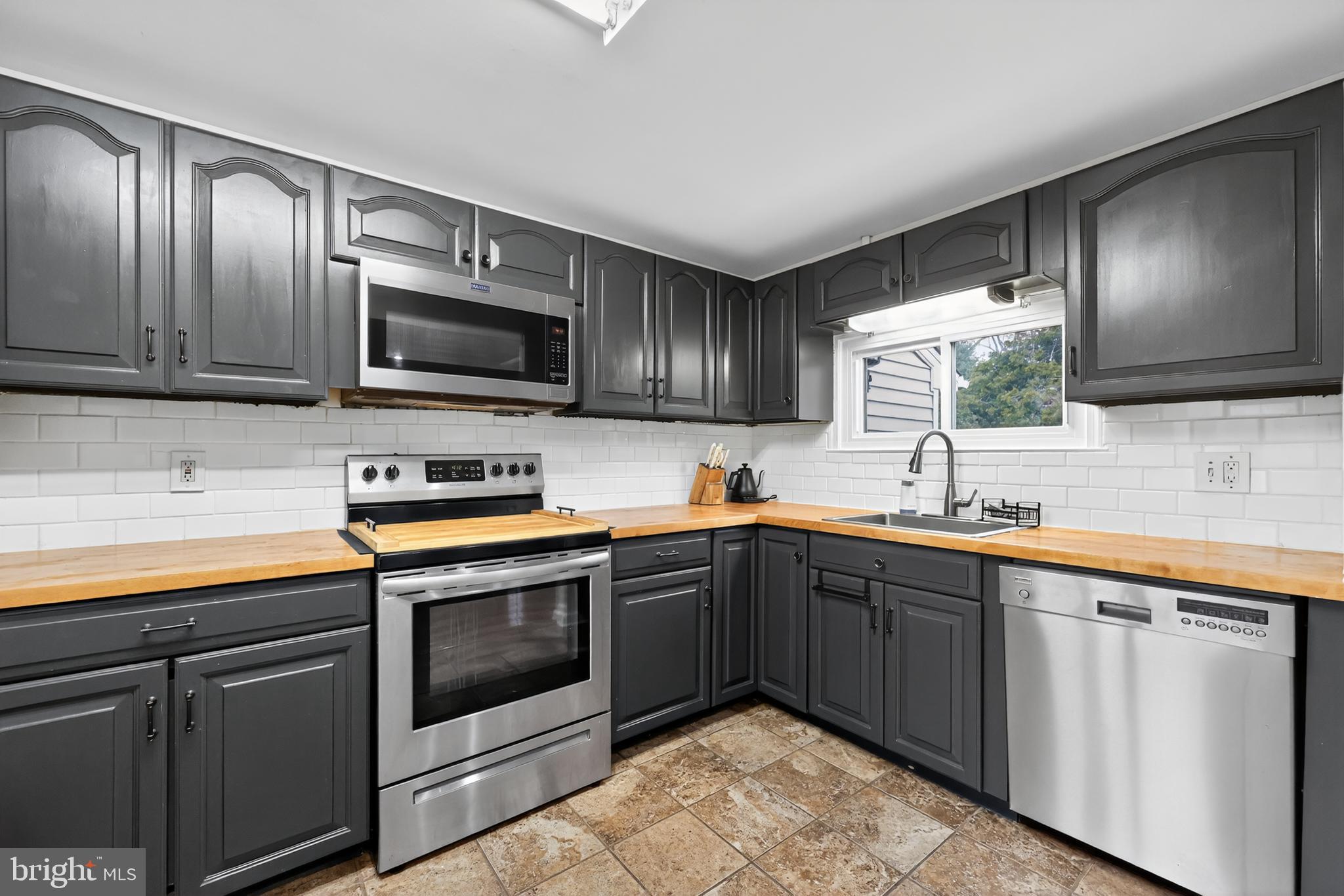 709 Manor Terrace Moorestown, NJ 08057 - Photo 11 of 37 a kitchen with stainless steel appliances granite countertop wooden cabinets a stove top oven a sink and dishwasher