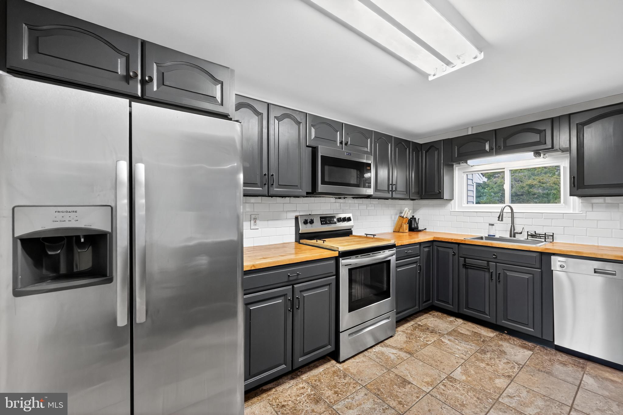 709 Manor Terrace Moorestown, NJ 08057 - Photo 13 of 37 a kitchen with stainless steel appliances granite countertop a refrigerator a sink a stove top oven and white cabinets