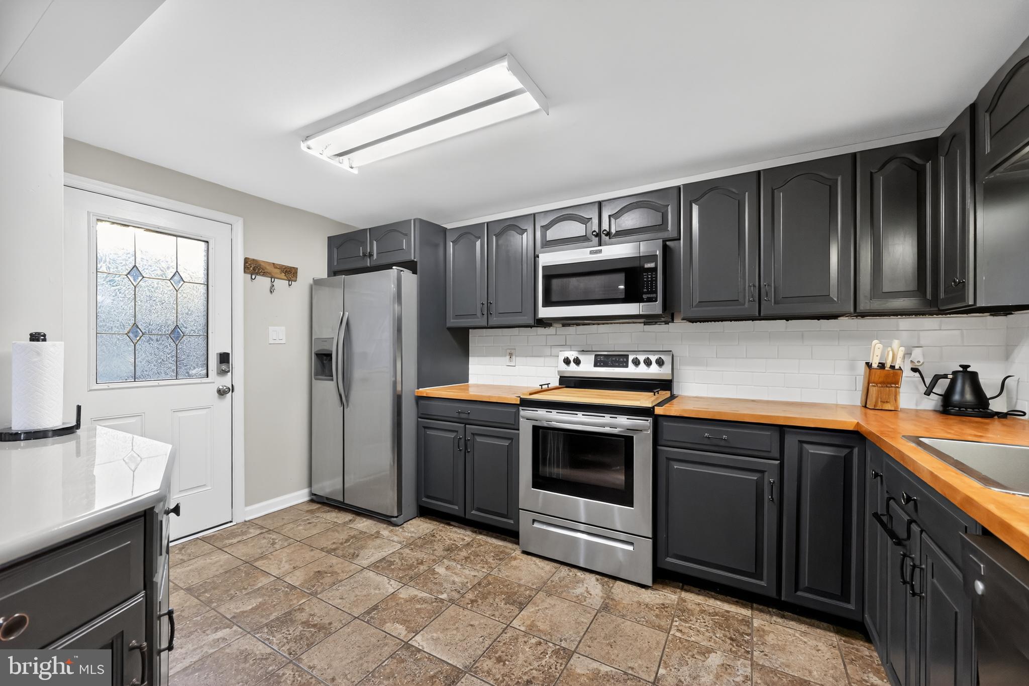 709 Manor Terrace Moorestown, NJ 08057 - Photo 14 of 37 a kitchen with stainless steel appliances granite countertop a stove refrigerator sink and microwave