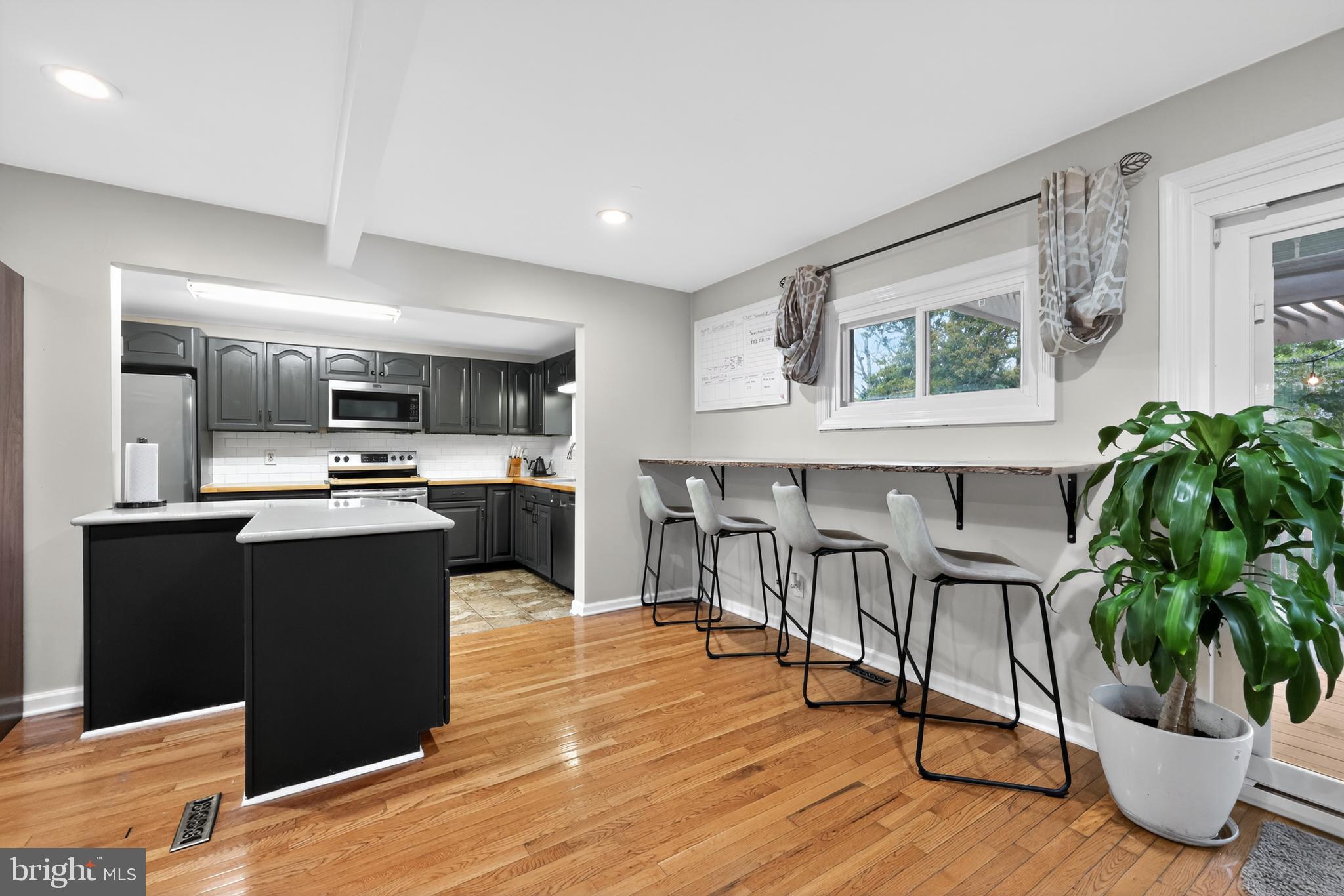 709 Manor Terrace Moorestown, NJ 08057 - Photo 10 of 37 a kitchen with stainless steel appliances granite countertop a refrigerator a stove a sink dishwasher and white cabinets with wooden floor