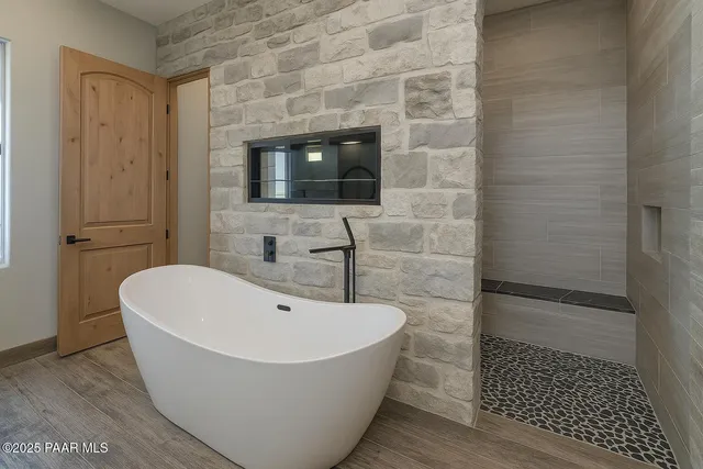 a bathroom with a granite countertop double vanity sink a mirror and bathtub