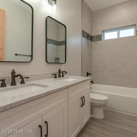a bathroom with a granite countertop sink mirror and bathtub