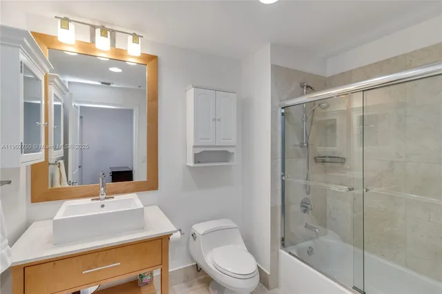 a bathroom with a bathtub shower sink vanity and toilet