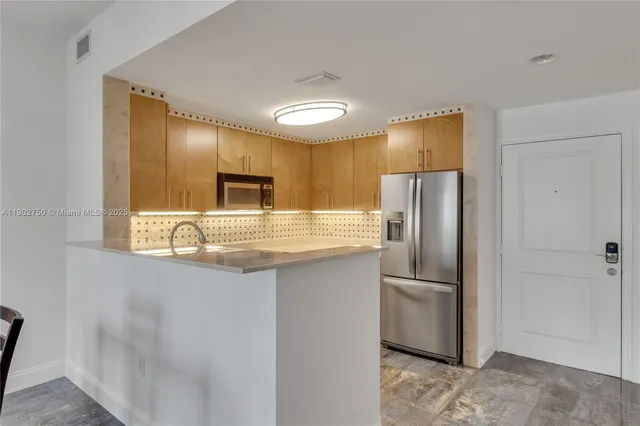 a kitchen with stainless steel appliances granite countertop a refrigerator and a stove