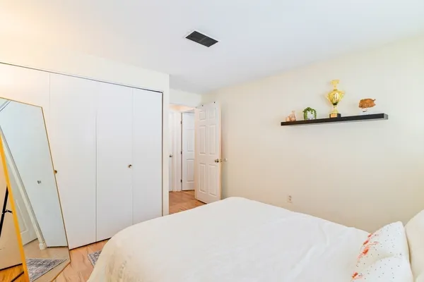 a bedroom with a bed and a refrigerator