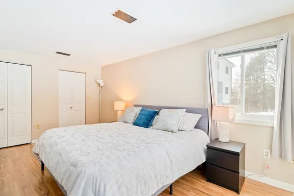 a large bed sitting in a bedroom next to a window
