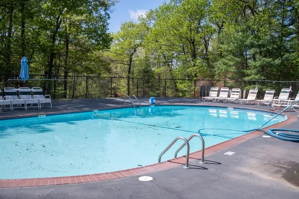 a swimming pool with some trees in the background