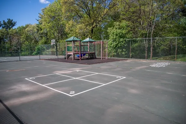 a view of a tennis ground with large trees