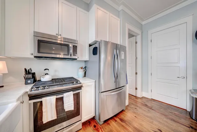 a kitchen with granite countertop a refrigerator stove and microwave