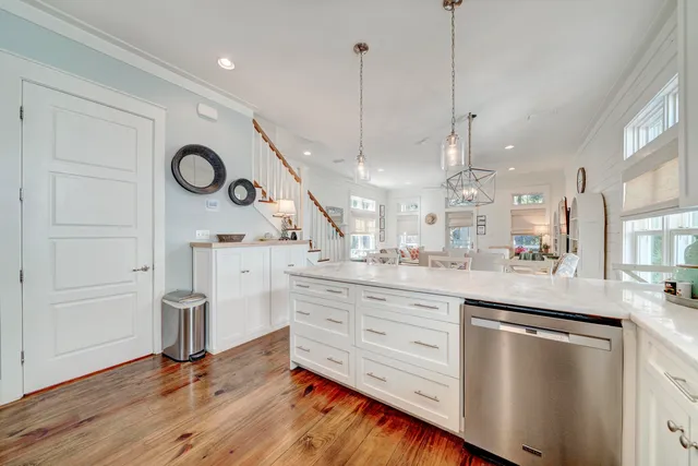 a open kitchen with white cabinets and wooden floor