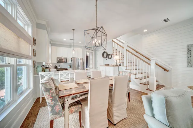 a dining room with furniture a chandelier and wooden floor