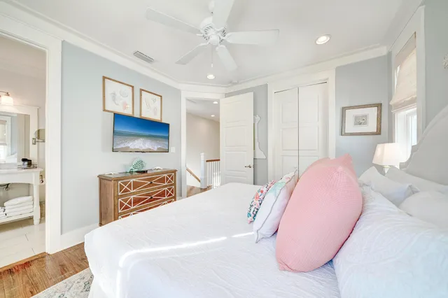 a bedroom with a bed a dresser and flat screen tv
