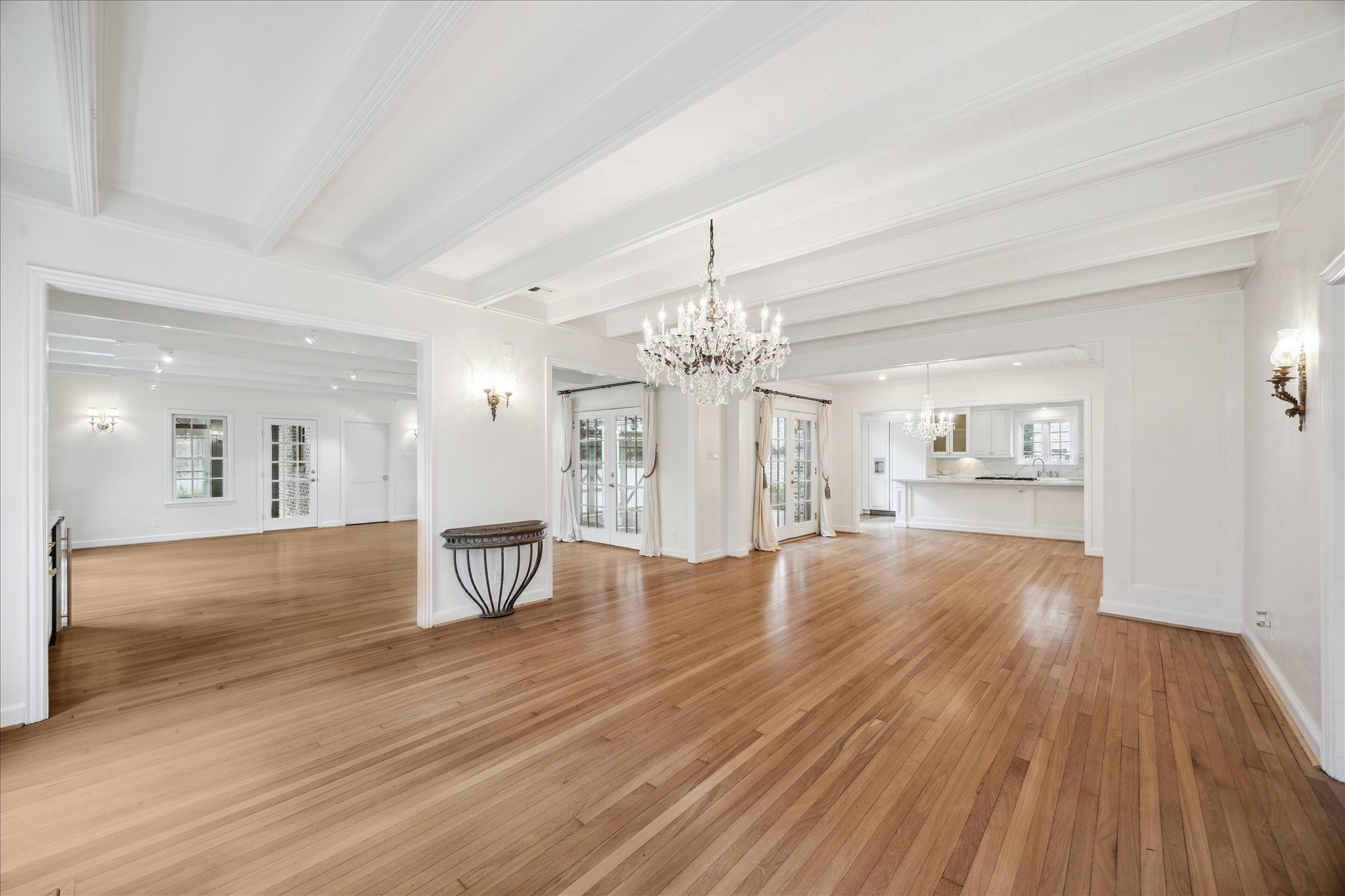 2117 Chilton Road Houston, TX 77019 - Photo 8 of 50 a view of an empty room and a kitchen with wooden floor