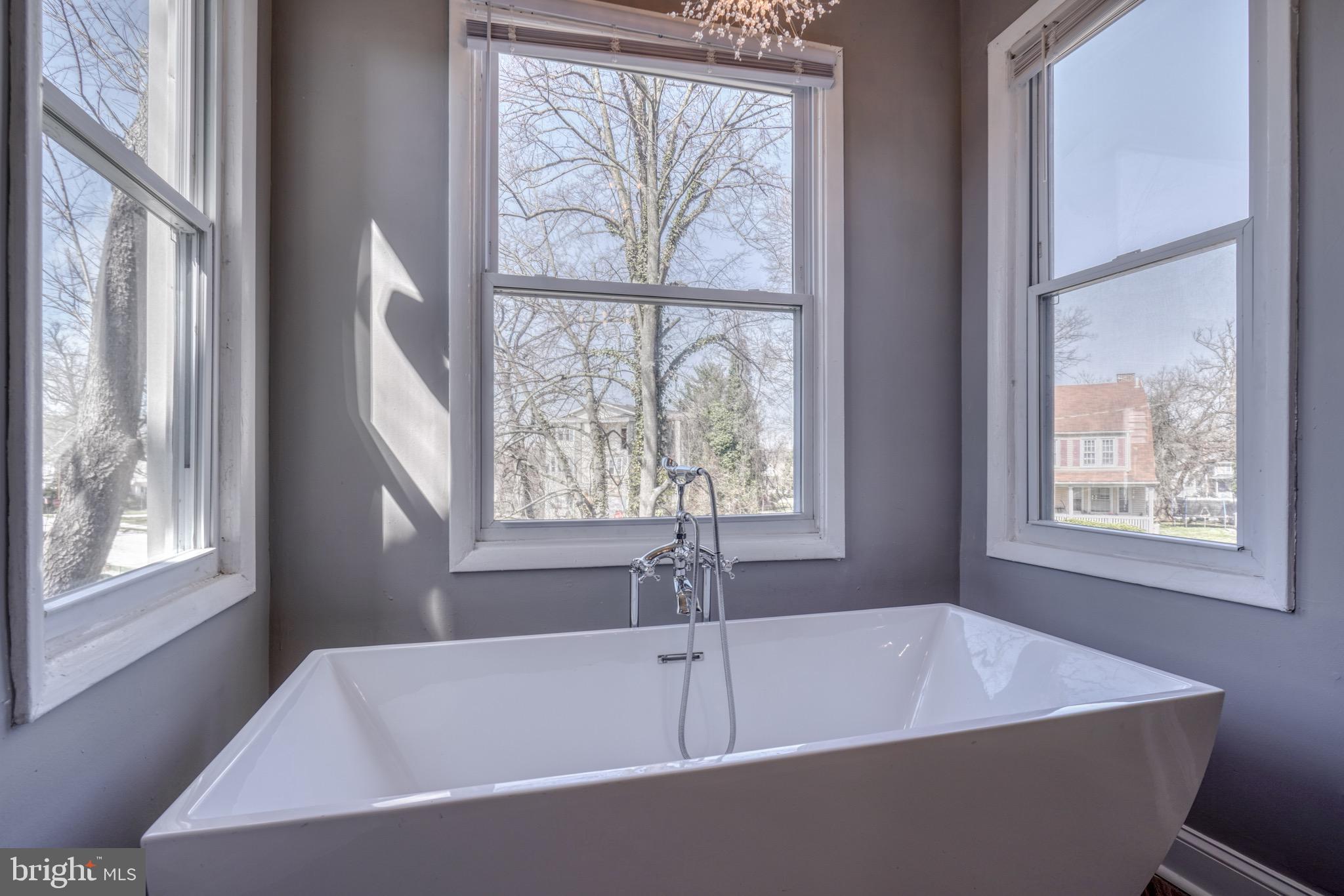 4107 Ridgewood Avenue Baltimore, MD 21215 - Photo 11 of 29 a white bath tub sitting in a bathroom next to a window