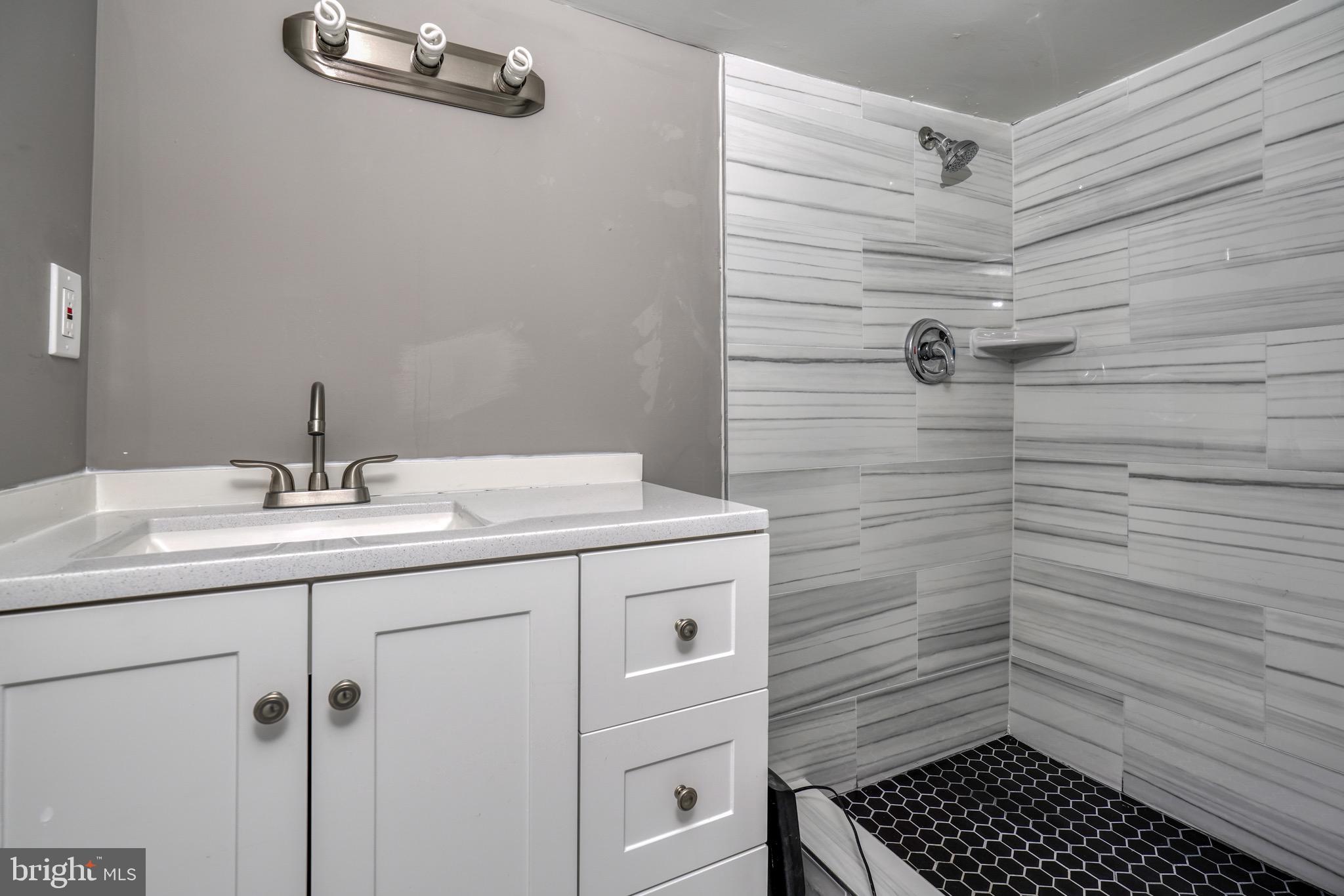 4107 Ridgewood Avenue Baltimore, MD 21215 - Photo 14 of 29 a bathroom with a sink toilet and shower