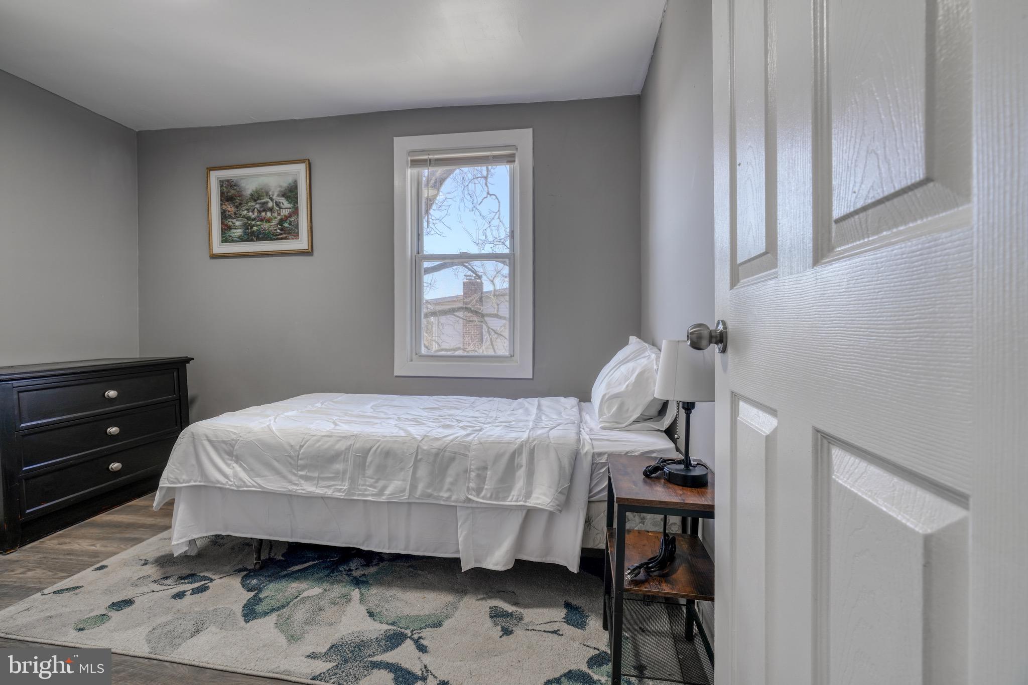 4107 Ridgewood Avenue Baltimore, MD 21215 - Photo 21 of 29 a bedroom with a bed and wooden floor