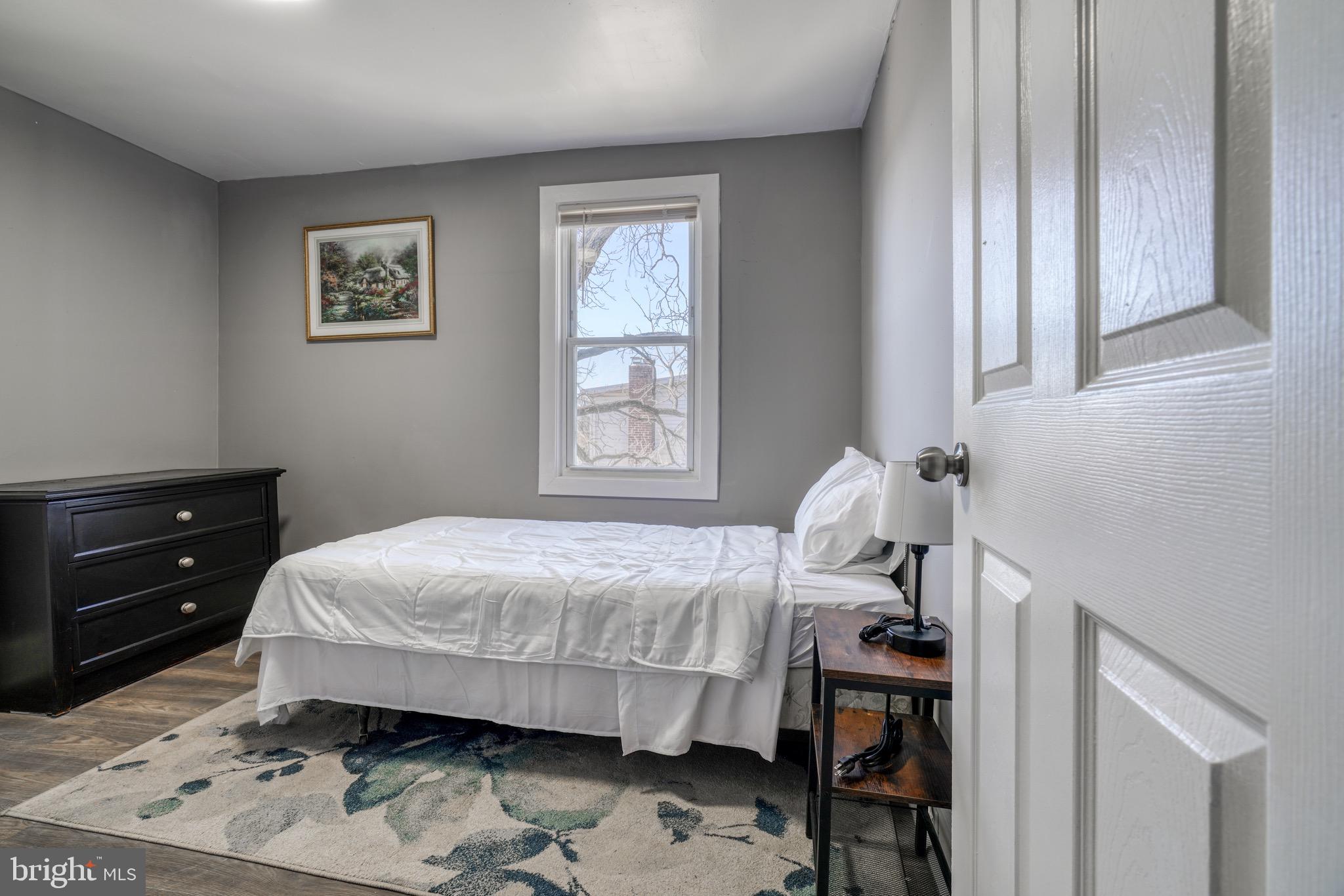4107 Ridgewood Avenue Baltimore, MD 21215 - Photo 27 of 29 a bedroom with a bed and wooden floor