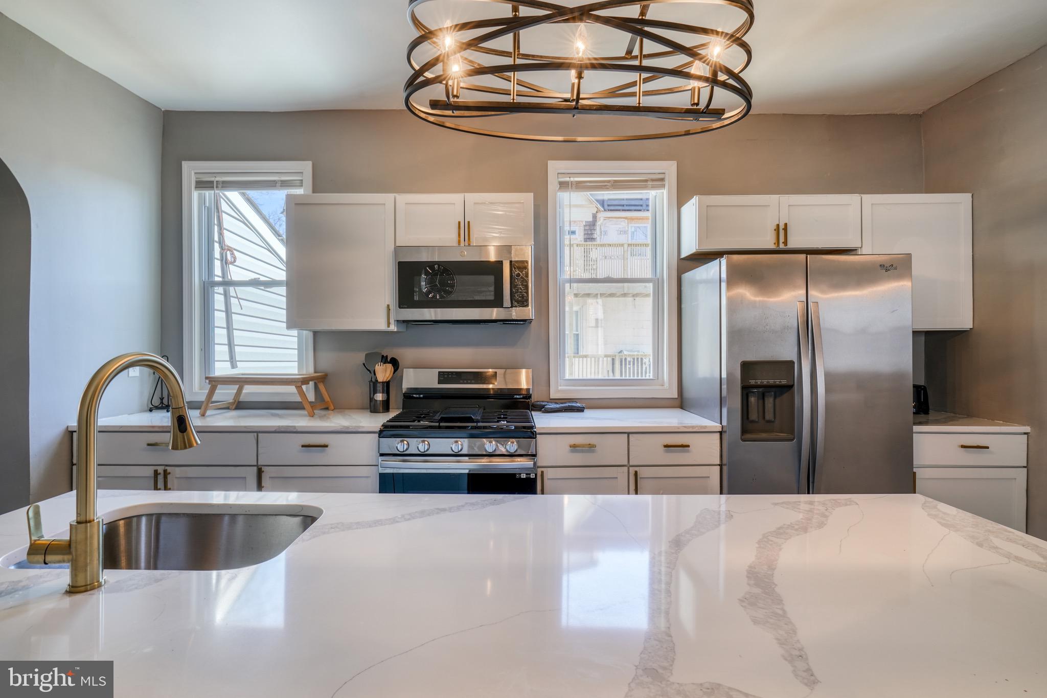 4107 Ridgewood Avenue Baltimore, MD 21215 - Photo 4 of 29 a kitchen with stainless steel appliances a stove refrigerator a sink and a microwave