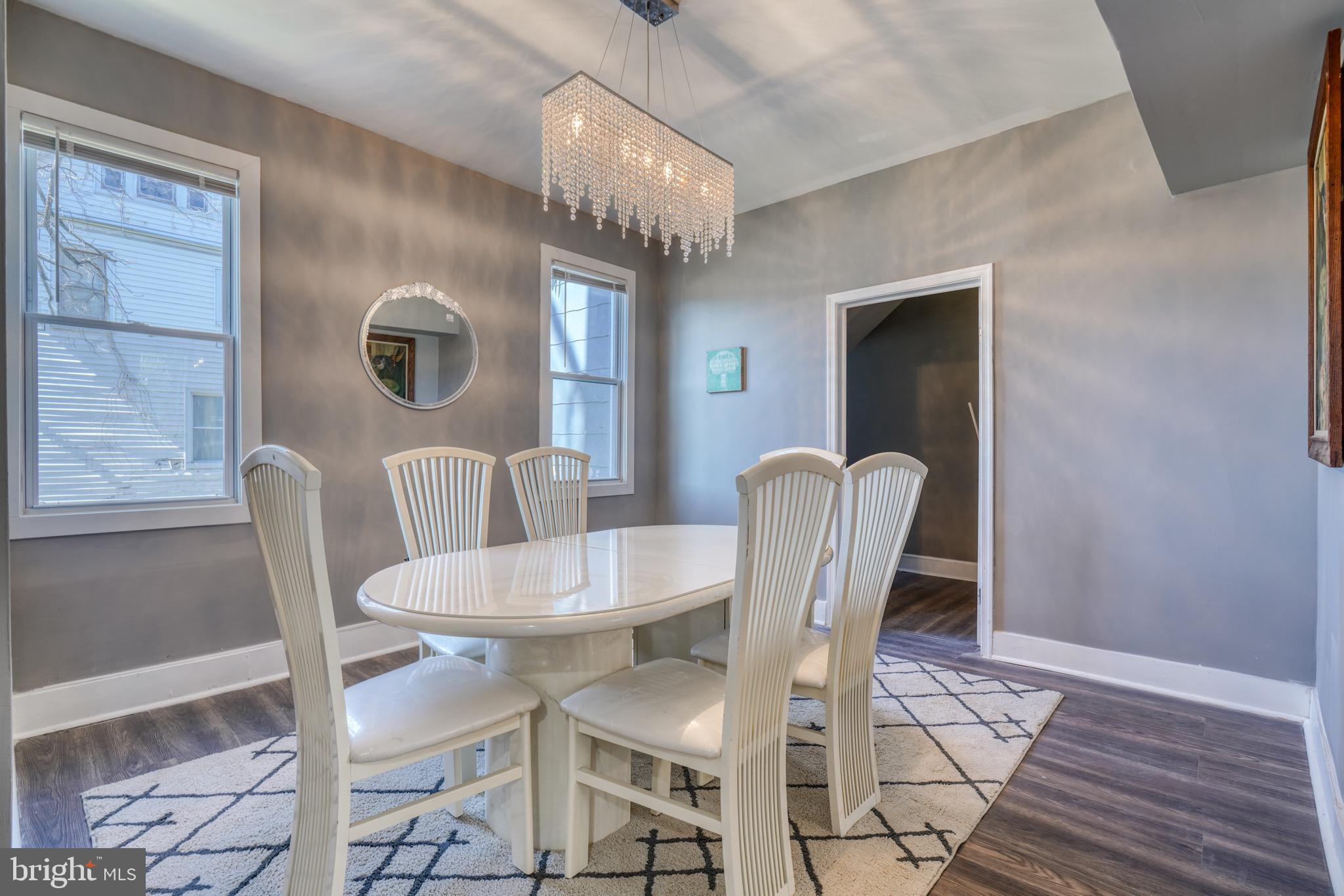 4107 Ridgewood Avenue Baltimore, MD 21215 - Photo 7 of 29 a dining room with furniture a chandelier and wooden floor