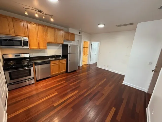 a kitchen with stainless steel appliances a stove a refrigerator and a sink