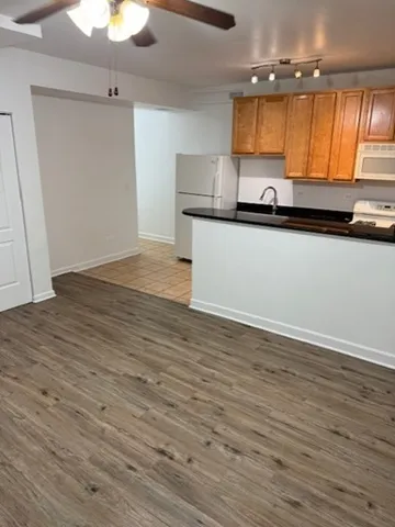 a kitchen with granite countertop wooden cabinets and a wooden floor