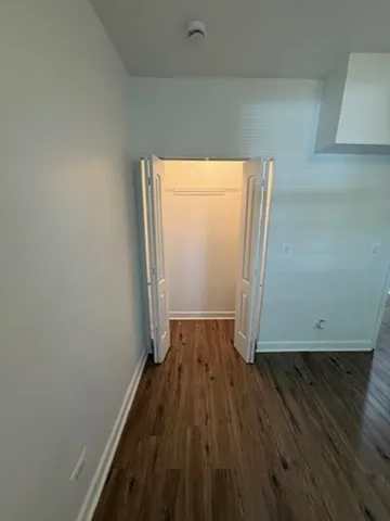 an empty room with wooden floor and a window