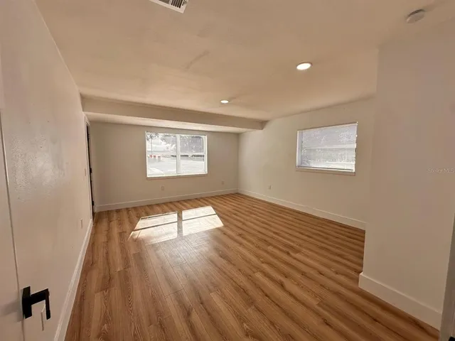 wooden floor in an empty room with a window