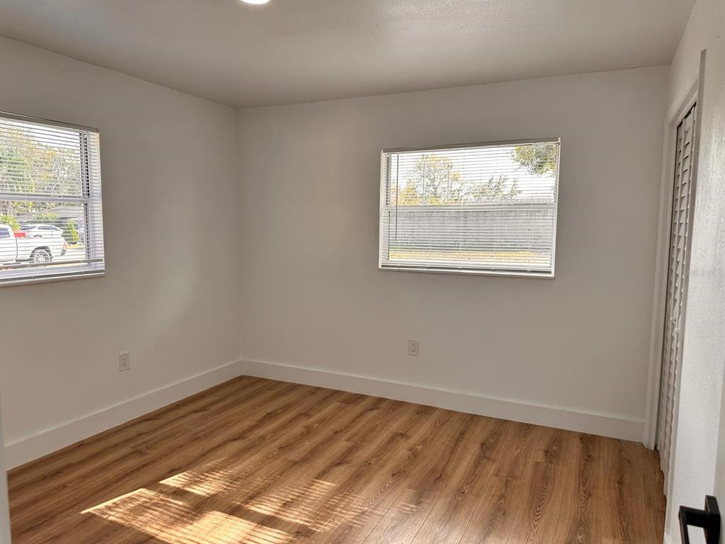 933 Windsor Street Lakeland, FL 33803 - Photo 26 of 47 an empty room with wooden floor and windows